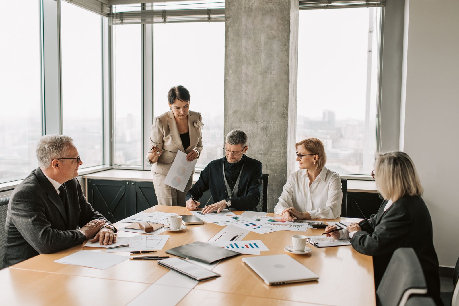 Business professionals reviewing reports together in a bright office meeting