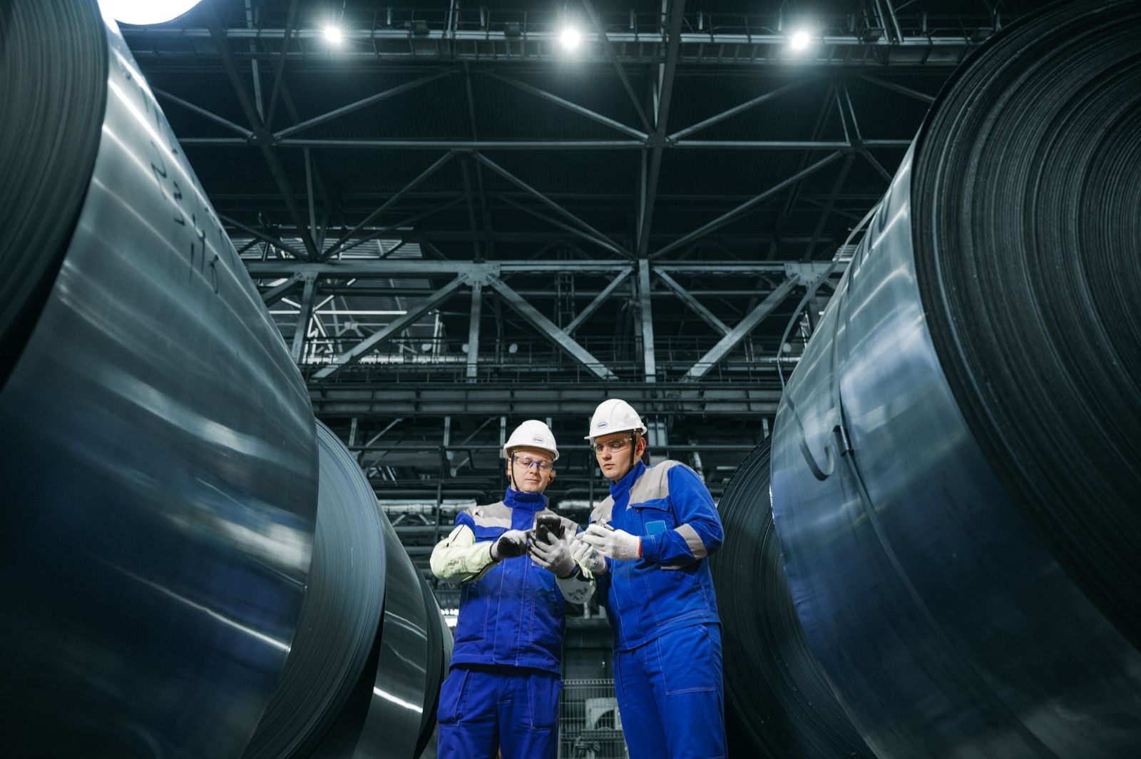 Industrial specialists reviewing steel production in a modern facility