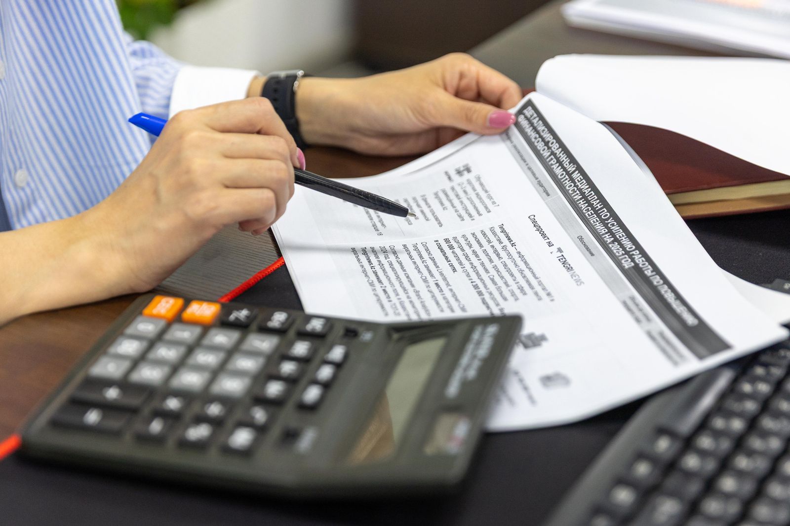 Professional reviewing financial documents with a calculator